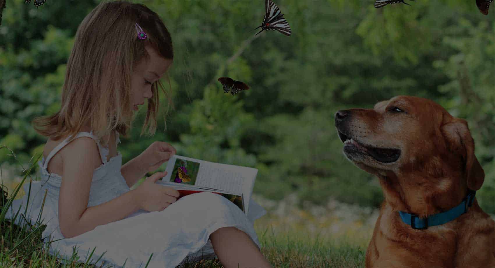 girl with dog in nature, reading a book
